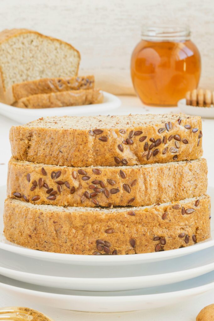 loaf to cut up bread made from flaxseed meal sitting on a white ceramic plate